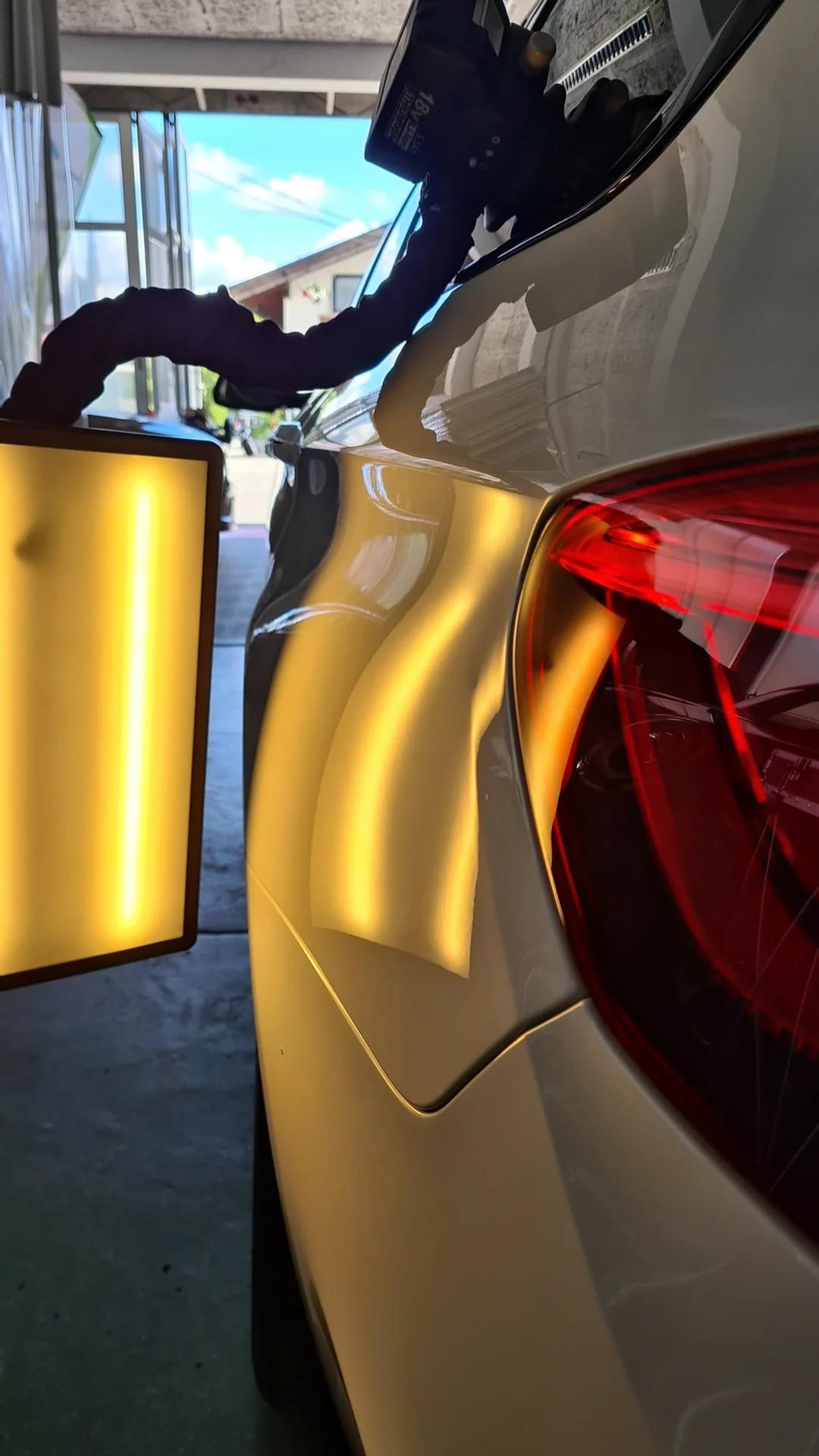 BMW F10 Seitenwand vor der Reparatur — Dellen sichtbar unter LED-Inspektionslicht in der Dellentechnik Gruber Werkstatt